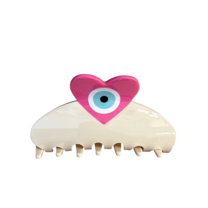 Hair clip with a pink heart and blue eye on a white background